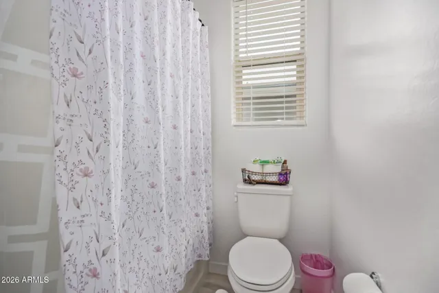 a white toilet sitting next to a shower curtain