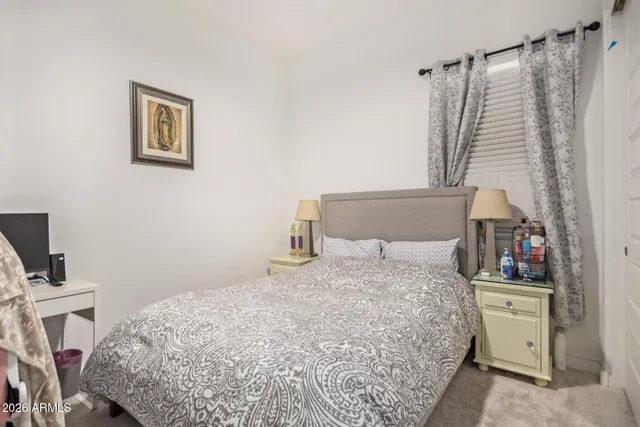 a bedroom with a bed and a flat tv screen on the dresser