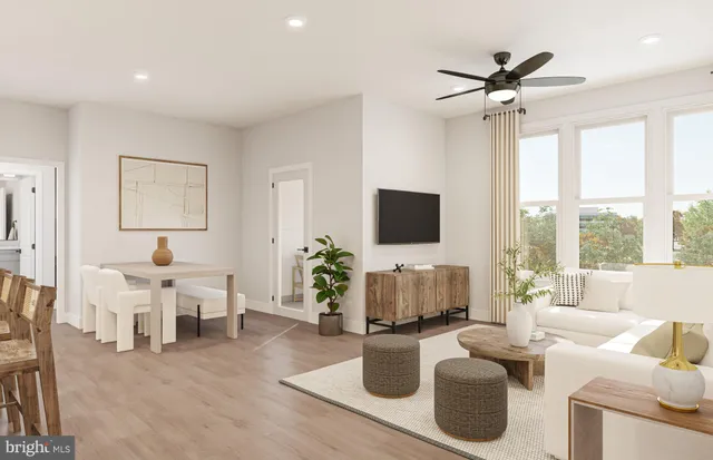 a kitchen with stainless steel appliances a refrigerator a stove a kitchen island with a dining table and wooden floor