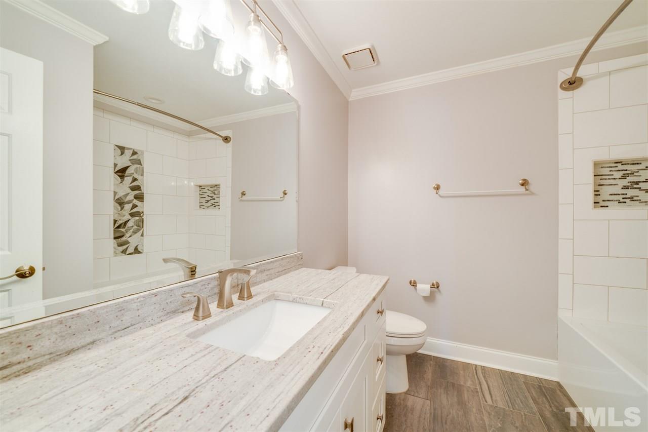 2116 Quail Ridge Road Raleigh, NC 27609 - Photo 19 of 30 a bathroom with a granite countertop sink a toilet and shower