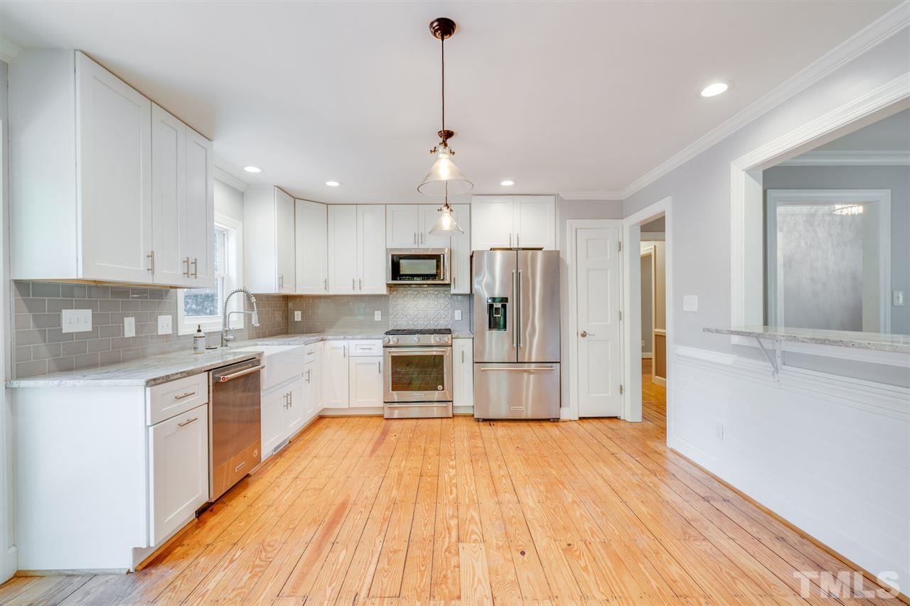 2116 Quail Ridge Road Raleigh, NC 27609 - Photo 7 of 30 a large kitchen with cabinets wooden floor and stainless steel appliances