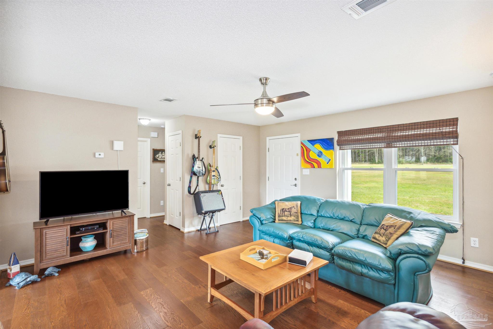 1911 Ard Field Road Jay, FL 32565 - Photo 6 of 47 a living room with furniture a flat screen tv and a large window