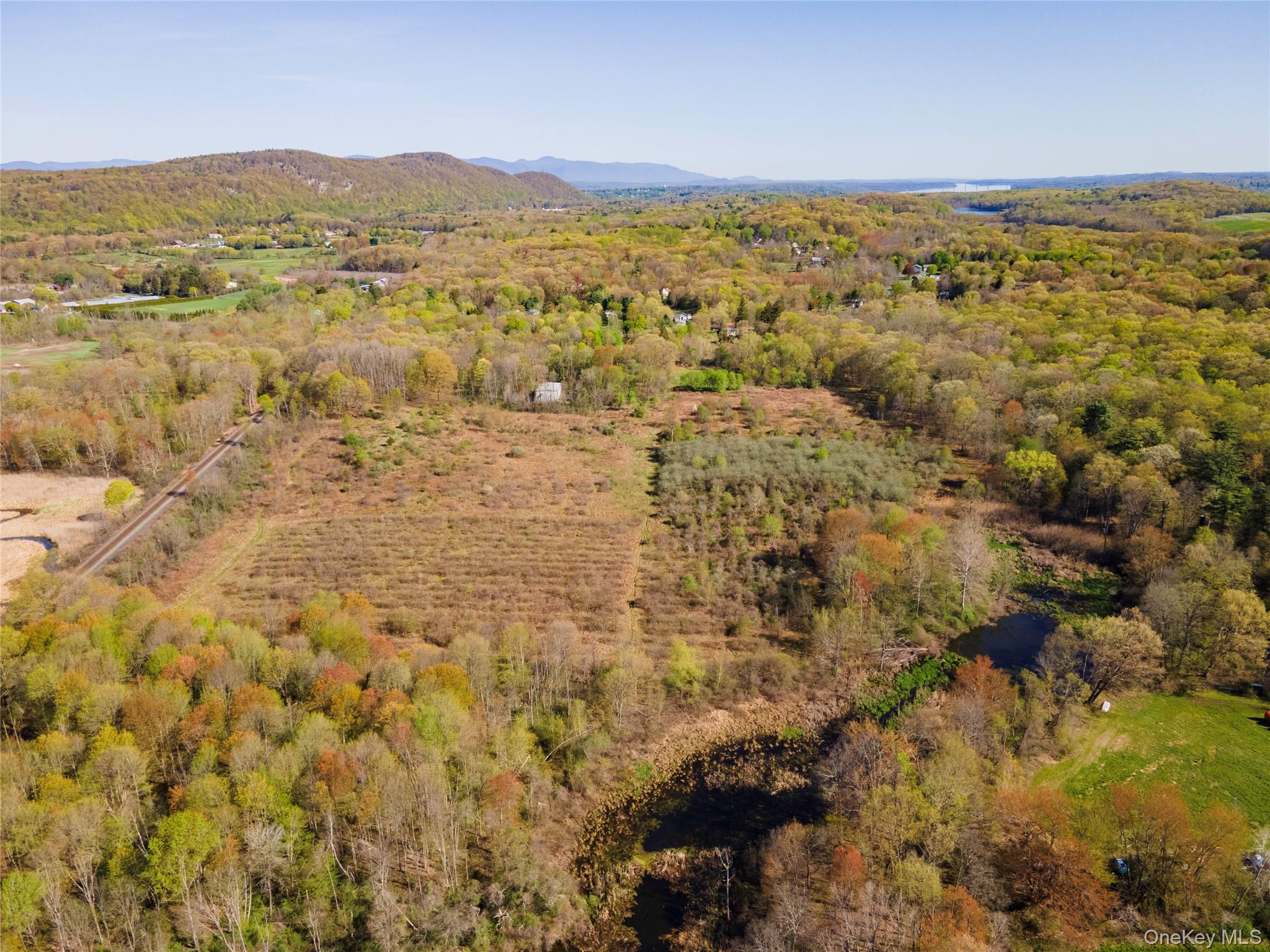 Aerial view of property's location featuring mountains and a forest
