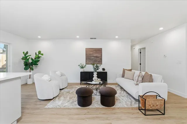 a living room with furniture a potted plant and white walls