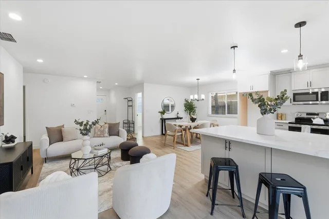 a living room with stainless steel appliances kitchen island granite countertop furniture a rug a kitchen island a sink and a stove