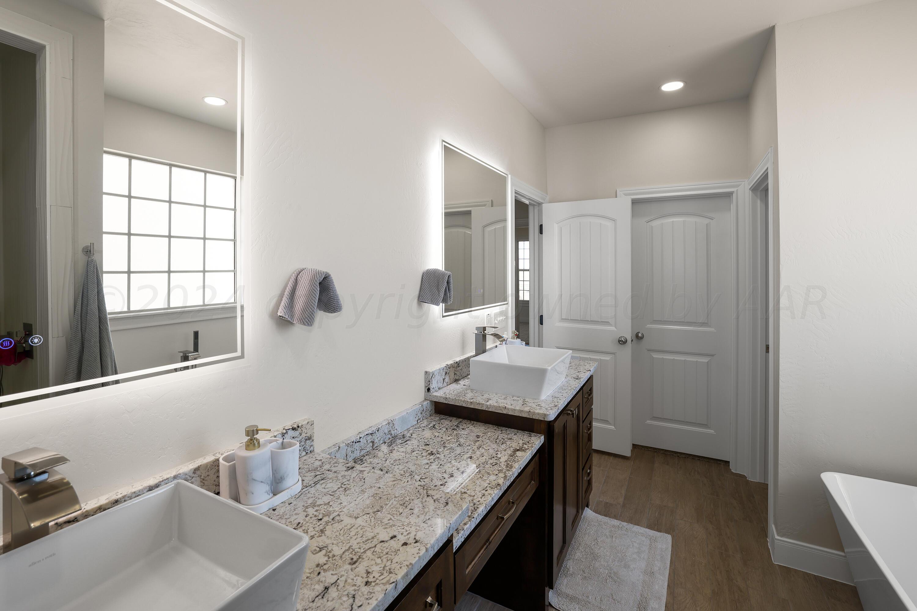 50 South Fm 2381 Amarillo, TX 79124 - Photo 15 of 31 a bathroom with a granite countertop sink a mirror and a bathtub