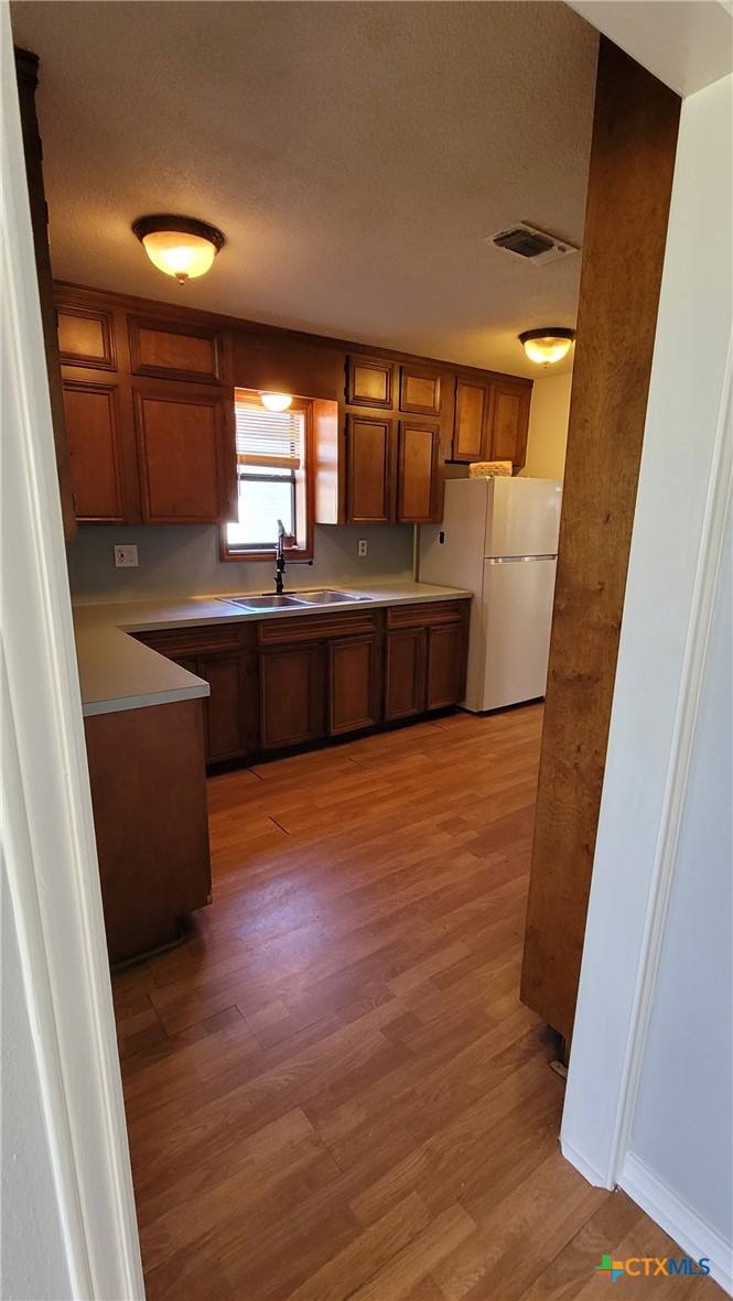 127-129 McAdams Road Goliad, TX 77963 - Photo 7 of 33 a large kitchen with a wooden floor and a large window