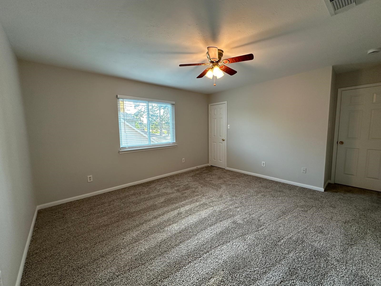 9210 Memorial Grove Drive Spring, TX 77379 - Photo 28 of 33 an empty room with windows and fan