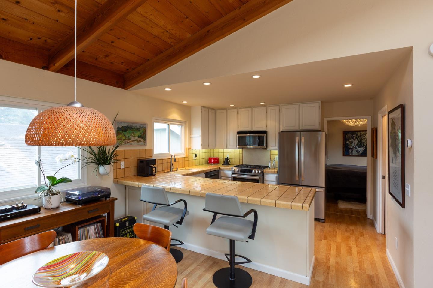 779 Alice Street Monterey, CA 93940 - Photo 5 of 27 a kitchen with stainless steel appliances kitchen island granite countertop a refrigerator a stove a sink a dining table and chairs with wooden floor
