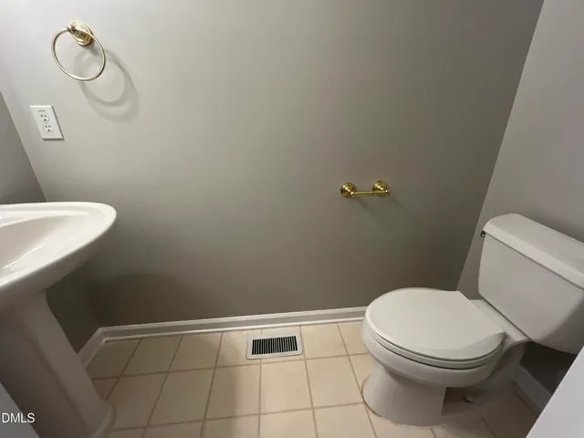 a bathroom with a toilet and a rug