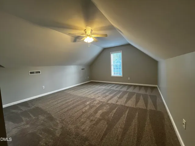 wooden floor in an empty room with a chandelier fan