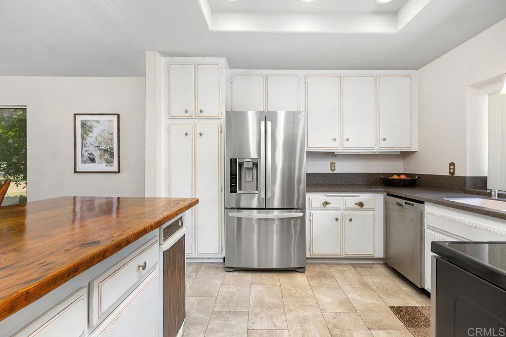 4119 Oak Island Lane Fallbrook, CA 92028 - Photo 17 of 54 a kitchen with stainless steel appliances granite countertop a refrigerator a stove and white cabinets