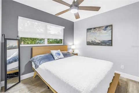 a bedroom with a bed and a painting on the wall