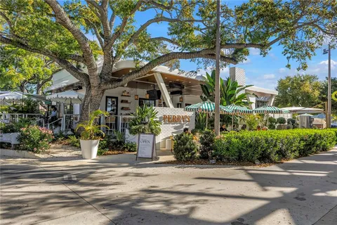 a view of a street with a building and palm trees