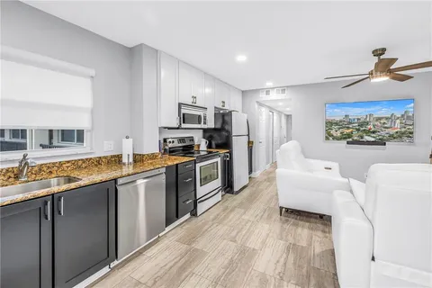 a kitchen with stainless steel appliances granite countertop a stove a sink and a refrigerator