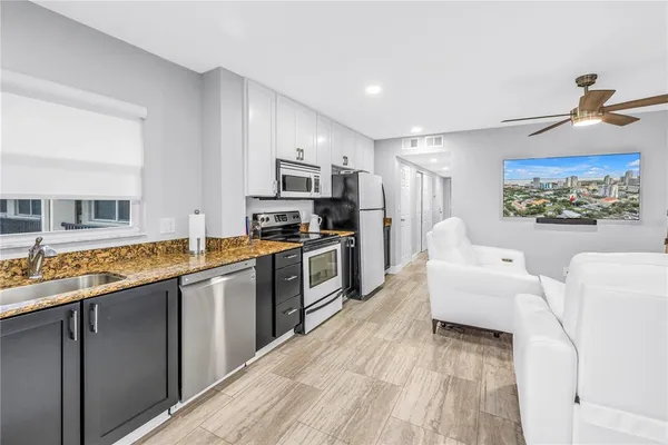 a kitchen with stainless steel appliances granite countertop a stove a sink and a refrigerator