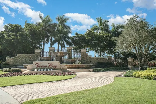 a view of a fountain in front of a house with large trees