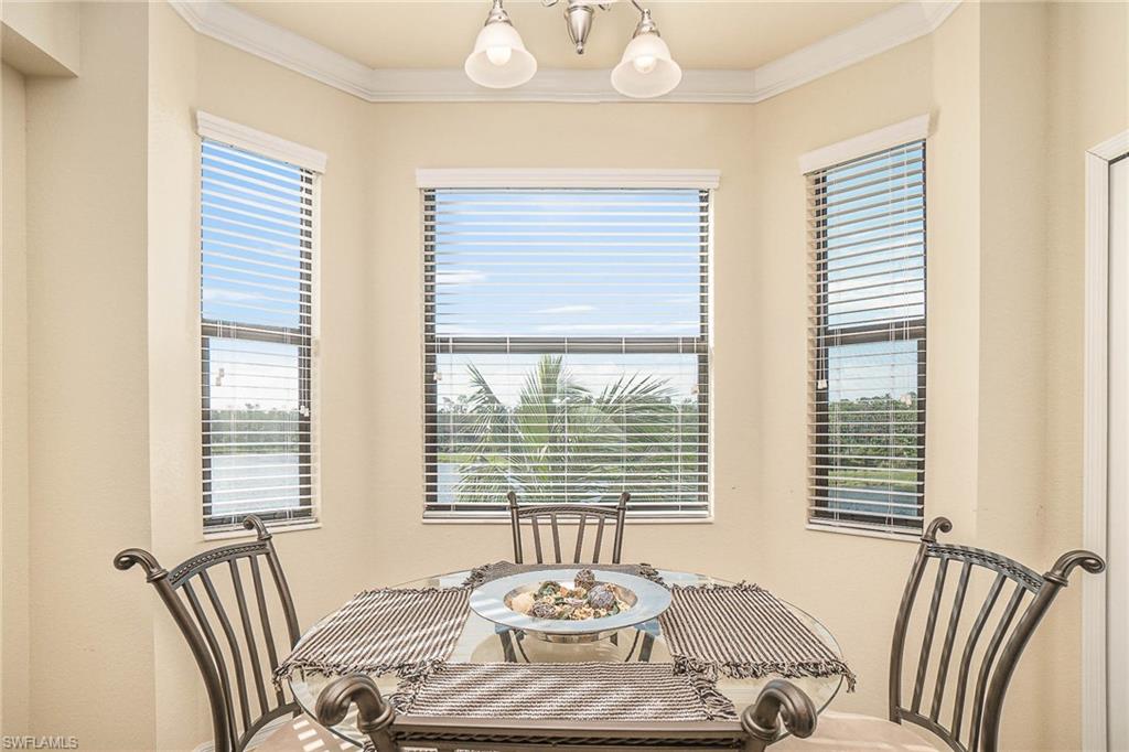 9731 Acqua Court, Unit 533 Naples, FL 34113 - Photo 7 of 22 a view of a dining room and livingroom with furniture wooden floor and a large window