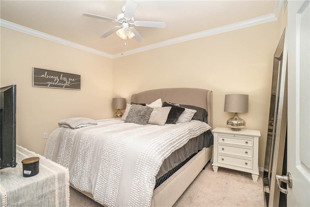 9731 Acqua Court, Unit 533 Naples, FL 34113 - Photo 9 of 22 a bedroom with a bed and a chandelier
