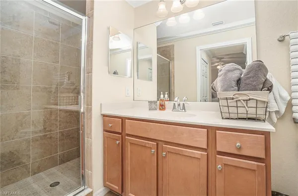 a bathroom with a granite countertop sink a mirror and shower