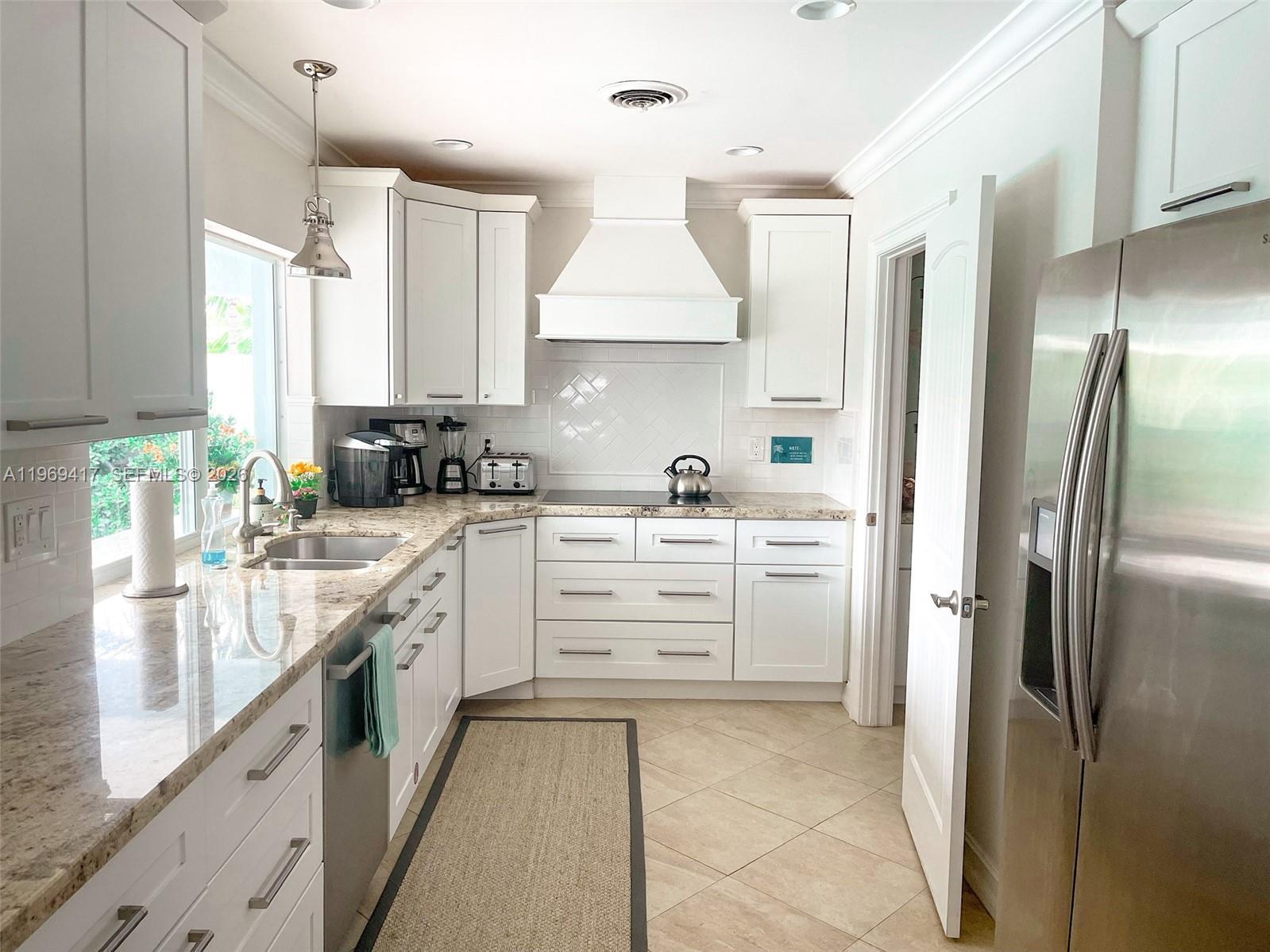 2932 Northeast 36th Street Lighthouse Point, FL 33064 - Photo 4 of 34 a kitchen with white cabinets and stainless steel appliances