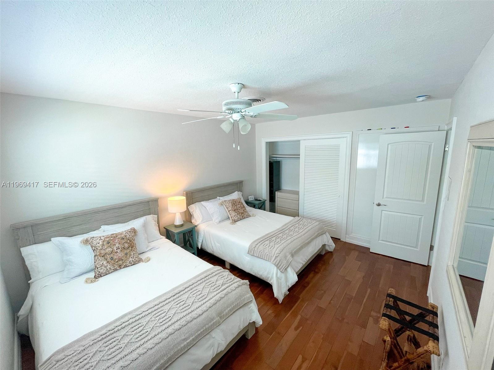 2932 Northeast 36th Street Lighthouse Point, FL 33064 - Photo 8 of 34 a bedroom with two beds and a chandelier