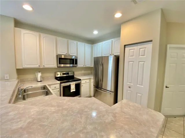 a kitchen with stainless steel appliances granite countertop a refrigerator stove and microwave