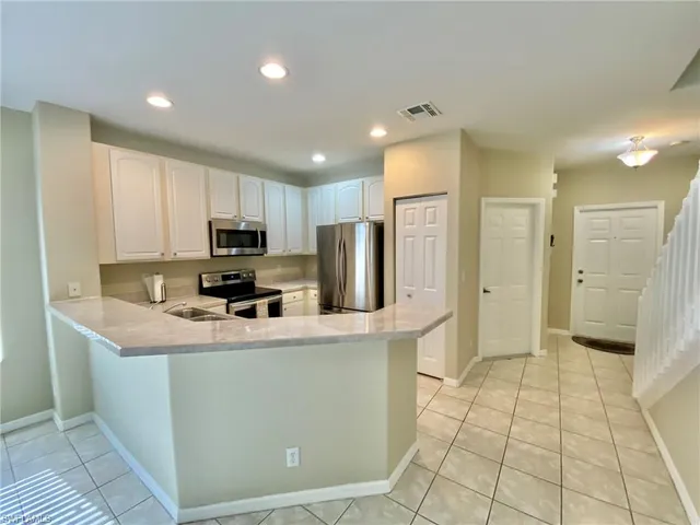 a kitchen with stainless steel appliances a refrigerator sink and microwave