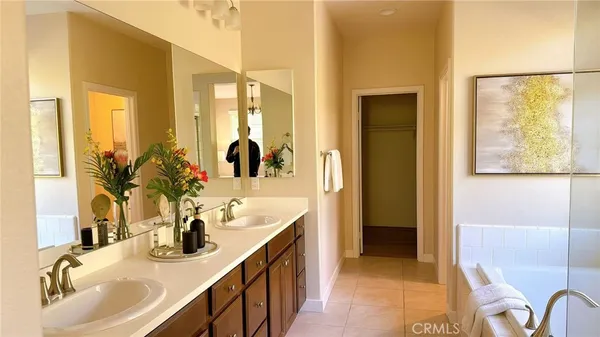a bathroom with a tub double vanity sink and mirrors