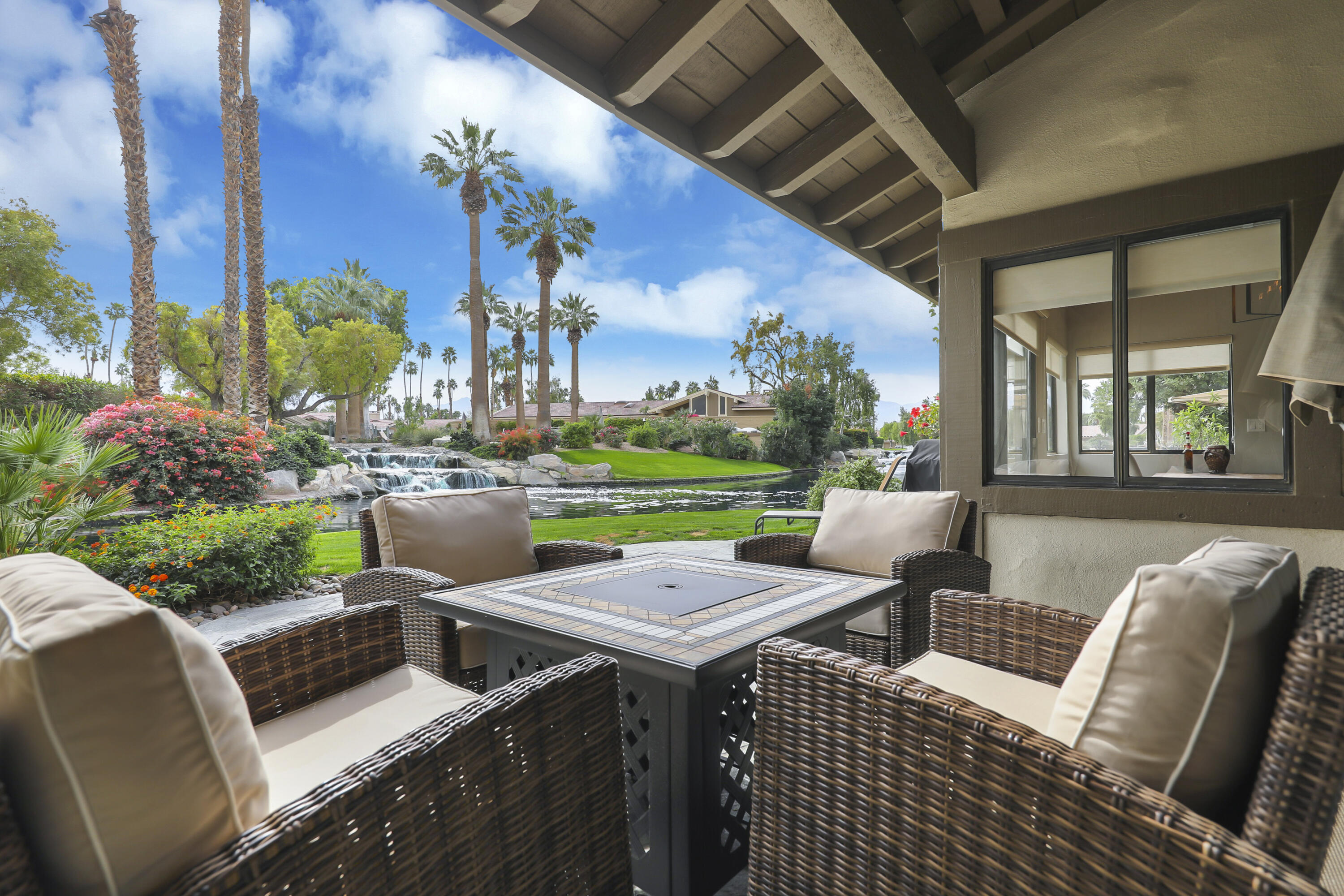 a view of a patio with couches table and chairs and potted plants