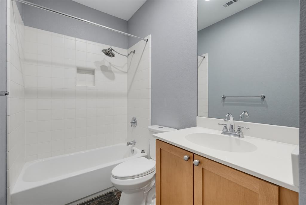 4830 Cedar Springs Road, Unit 30 Dallas, TX 75219 - Photo 30 of 32 Full bathroom featuring a single vanity with wood-finish cabinetry and a light-toned countertop