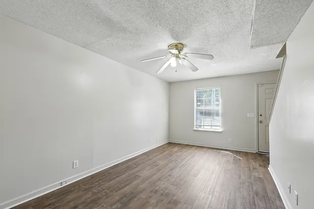 an empty room with wooden floor and windows