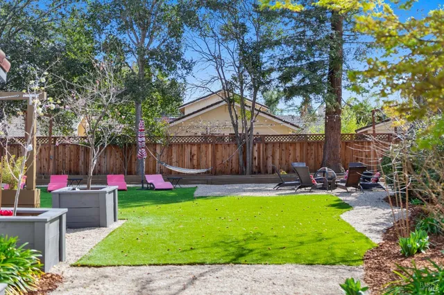 a view of a patio with table and chairs with wooden fence and plants