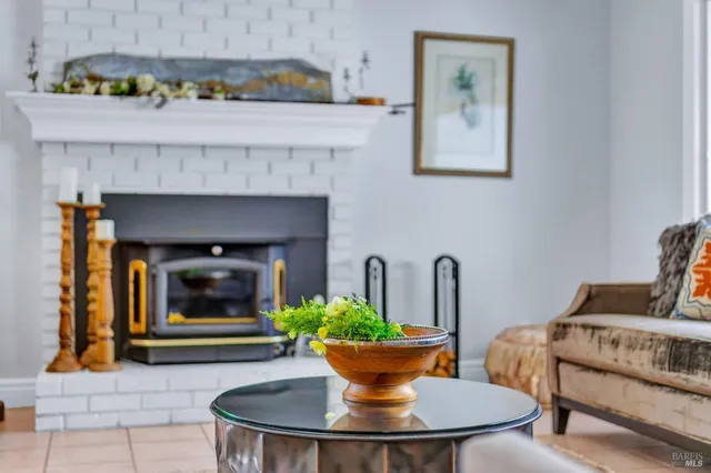 a view of a patio with table and chairs potted plants and floor to ceiling window