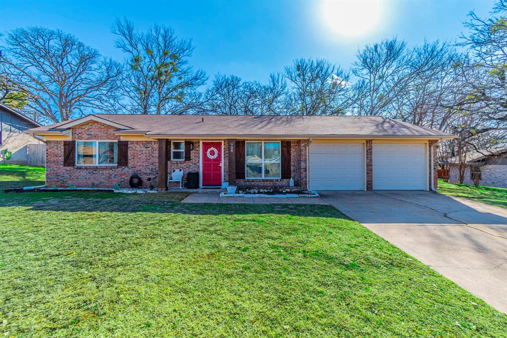 Classic brick home with charming curb appeal, mature trees, and a welcoming front porch.