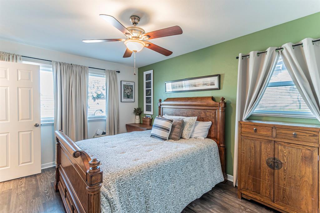 708 North Stewart Street Azle, TX 76020 - Photo 11 of 25 Comfortable primary bedroom with updated flooring, ceiling fan, and calming accent wall.
