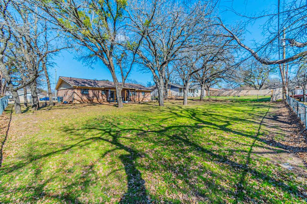708 North Stewart Street Azle, TX 76020 - Photo 23 of 25 Large fenced backyard with mature shade trees and room to customize or entertain.