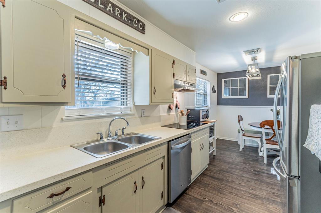 708 North Stewart Street Azle, TX 76020 - Photo 6 of 25 Galley-style kitchen featuring ample cabinetry, updated counters, and stainless appliances.