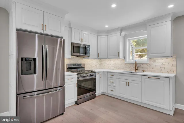 a kitchen with cabinets stainless steel appliances and window
