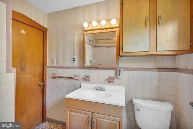 a bathroom with a sink a toilet and mirror