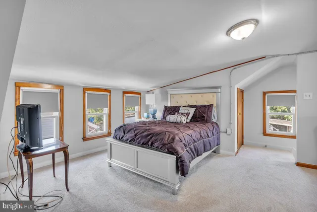 a spacious bedroom with a bed and glass door