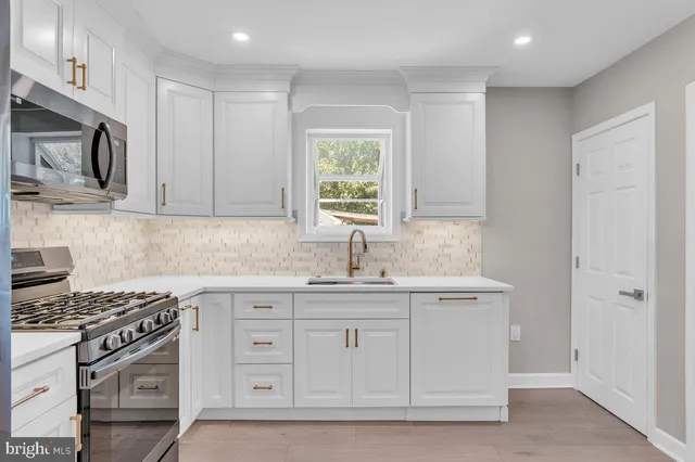 a kitchen with stainless steel appliances granite countertop a sink stove and cabinets