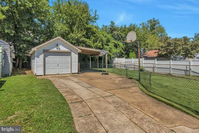 a front view of a house with a garden and trees