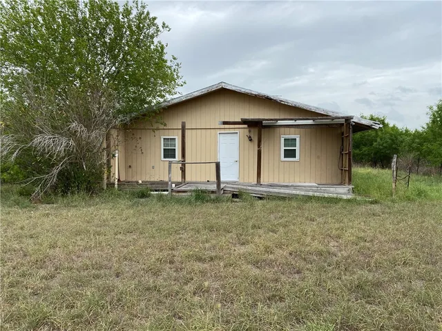 a house with green field in front of it