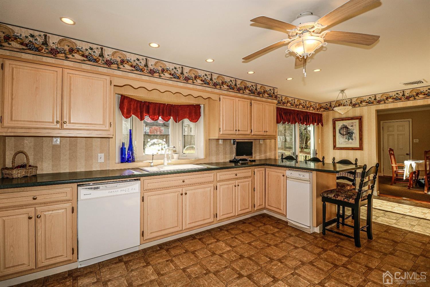 147 Oxford Road Colonia, NJ 07067 - Photo 6 of 31 Beautiful, expansive cabinet filled eat in kitchen with Corian counters, breakfast bar, recessed lights, ceiling fan plus filled with natural light.