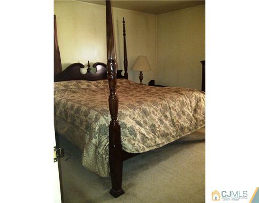 62 Meadow Road Edison, NJ 08817 - Photo 6 of 14 a bedroom with a bed and a mirror