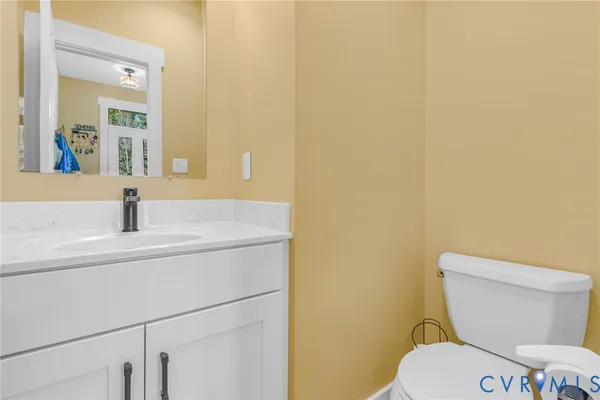a bathroom with a sink a toilet a mirror and vanity