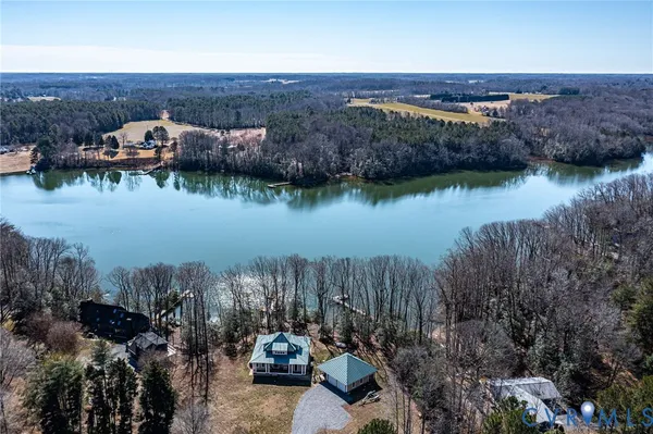 an aerial view of a house with a yard and lake view