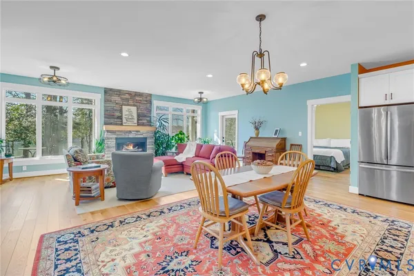a dining room with furniture a chandelier and wooden floor