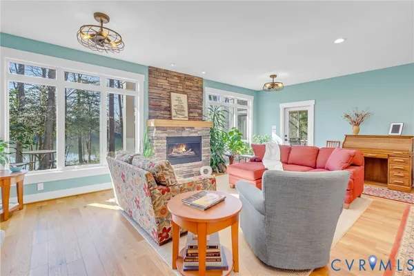 a living room with furniture a fireplace and a floor to ceiling window